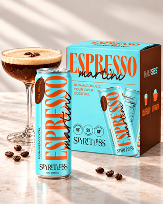 Spiritless non-alcoholic Espresso Martini 12 oz turquoise can and 4-pack carton beside a coupe of Espresso Martini with coffee beans